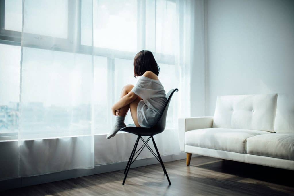 A seated girl looking out a window