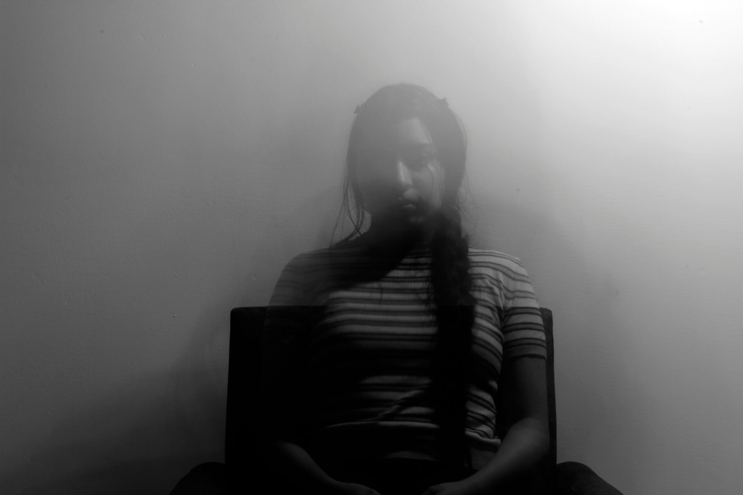 young woman sitting in chair potentially experiencing cannabis-induced psychosis